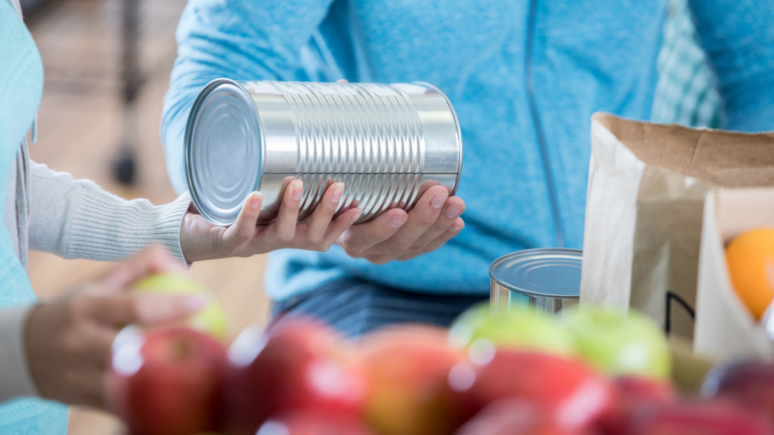 Two hands holding a tin can of food