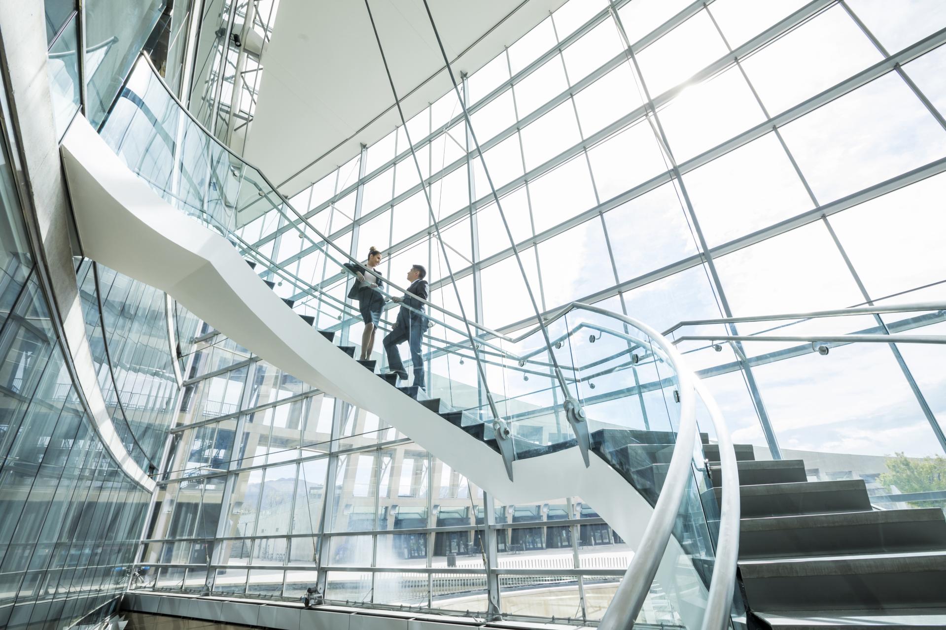 Two people walking up staircase 